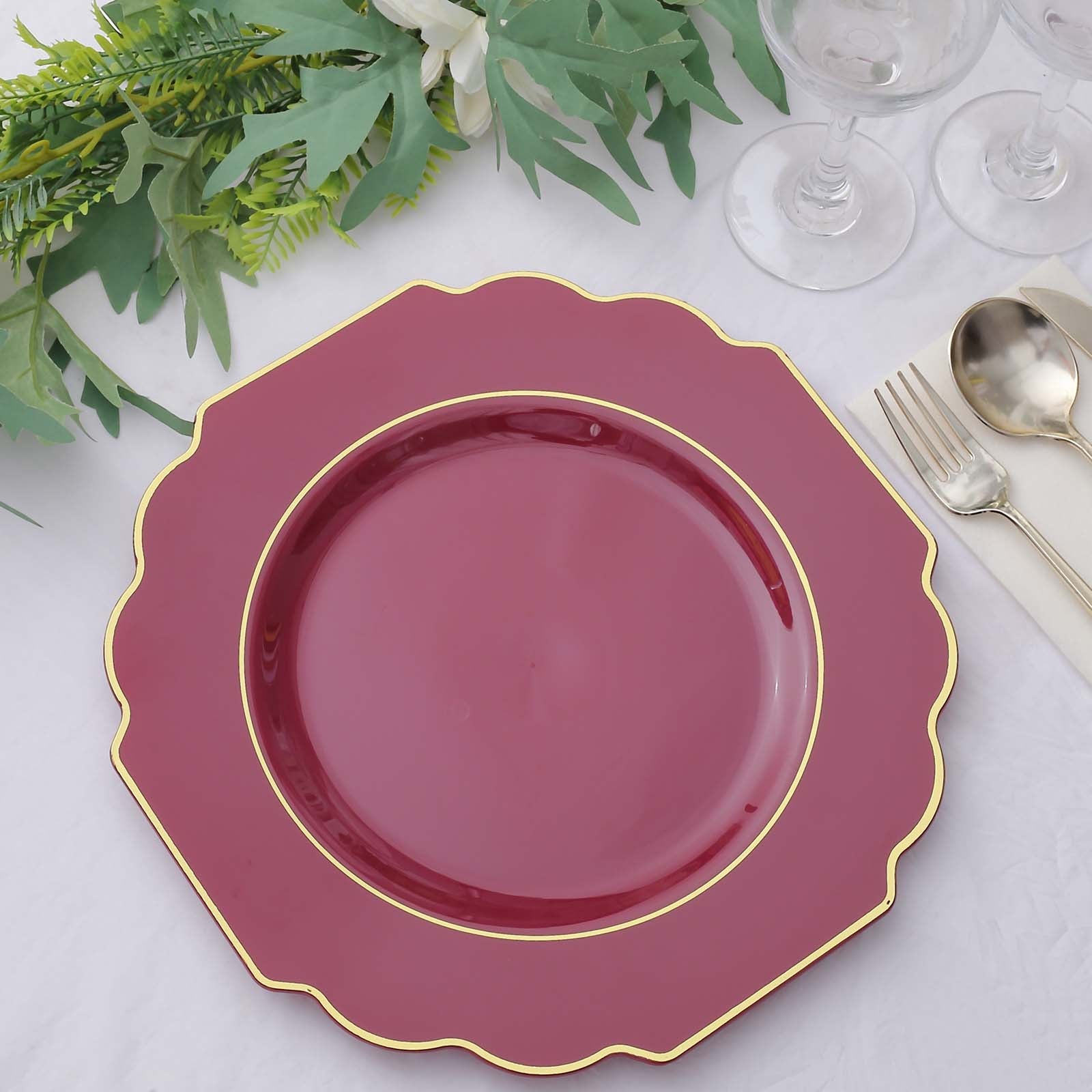 Burgundy hard plastic Baroque dinner plate with gold rim.