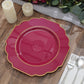 Burgundy hard plastic Baroque dinner plate with gold rim on a wooden table.
