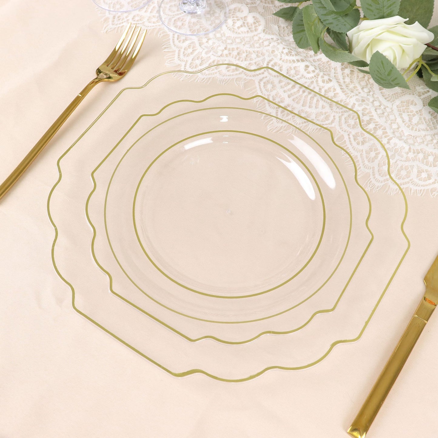 Clear hard plastic dessert plates with gold rim on a table setting.