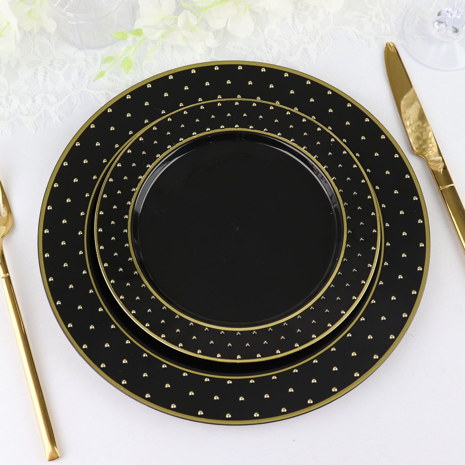 Black and gold 3D round plastic appetizer plates with polka dot rim.