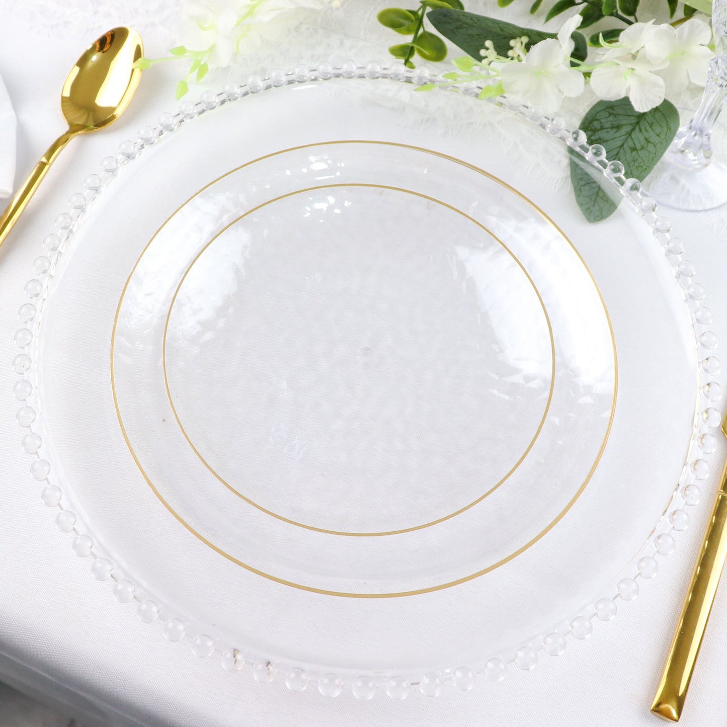 Clear hammered round plastic dessert plates with gold rim.