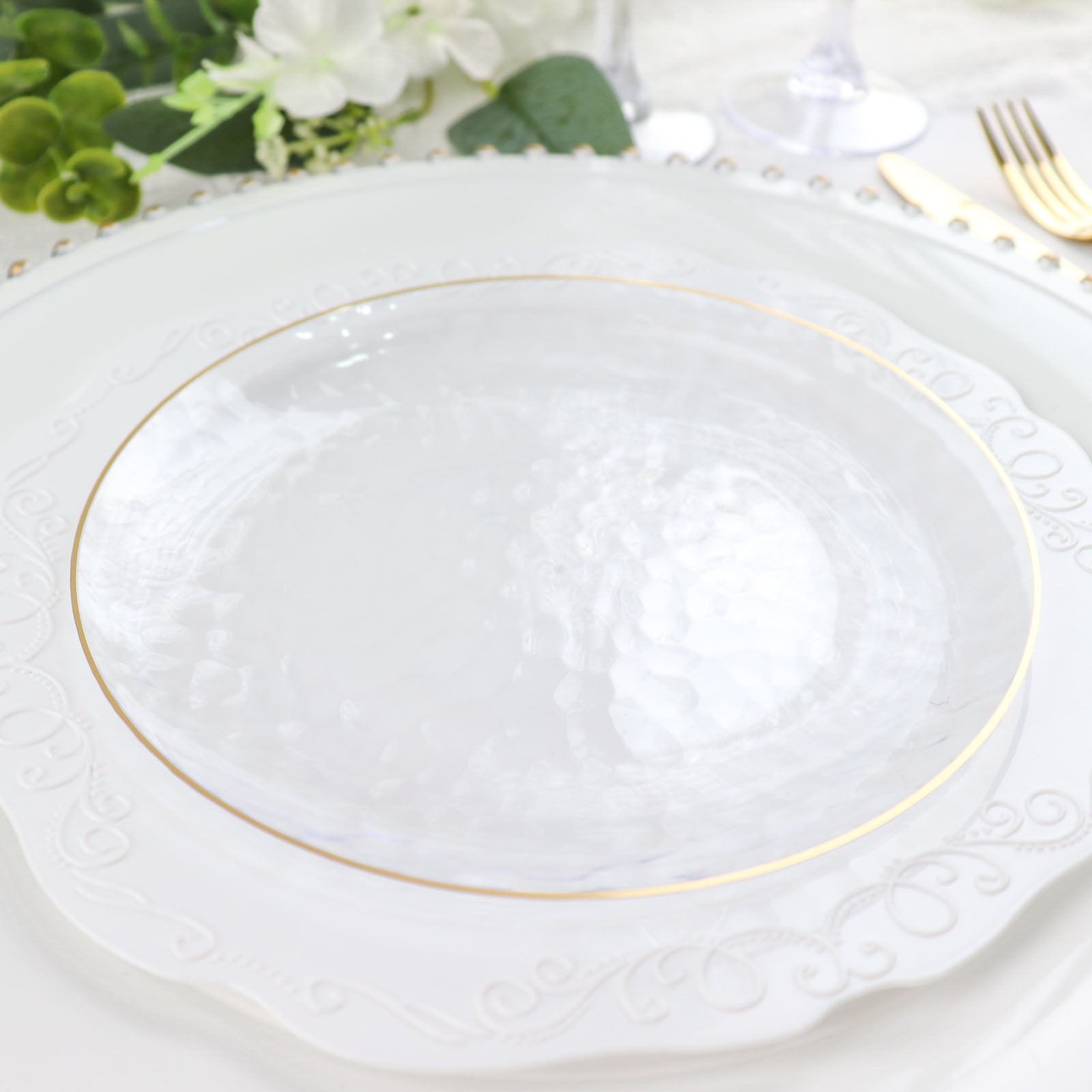 Clear hammered round plastic plate with gold rim.