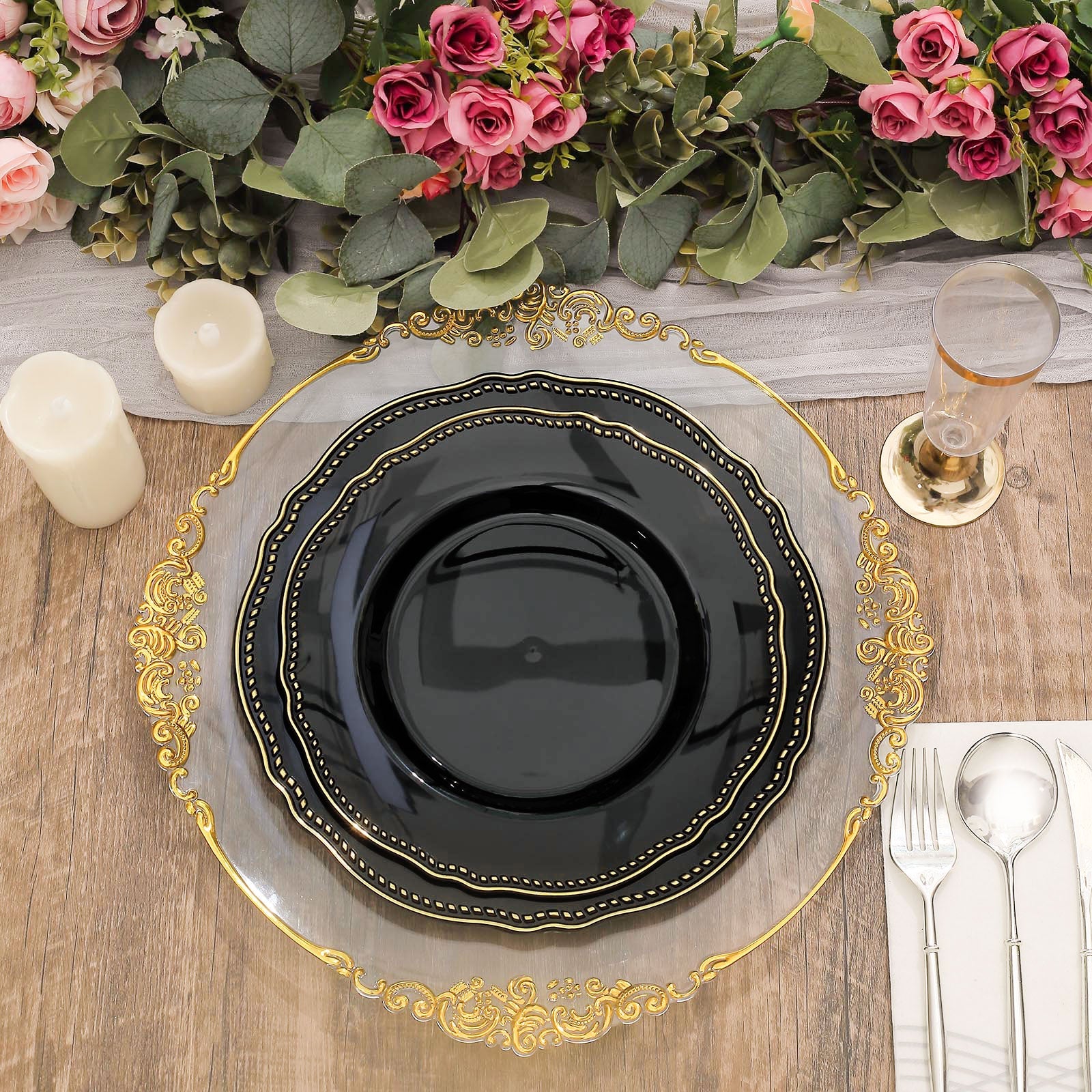 Elegant black plate on a gold-trimmed charger with candles and floral arrangement.