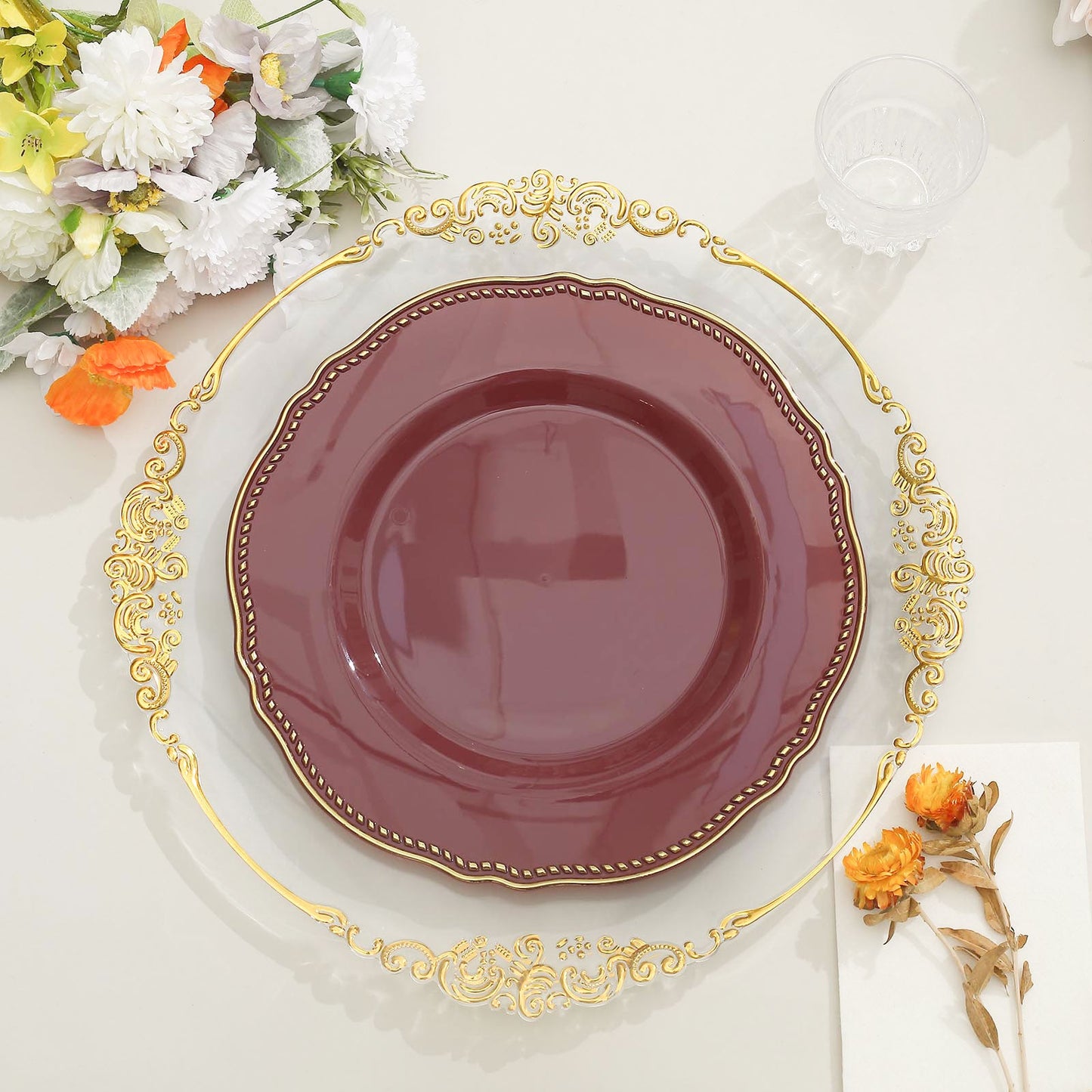Elegant maroon plate on a decorative gold charger with floral accents. Perfect for dining.