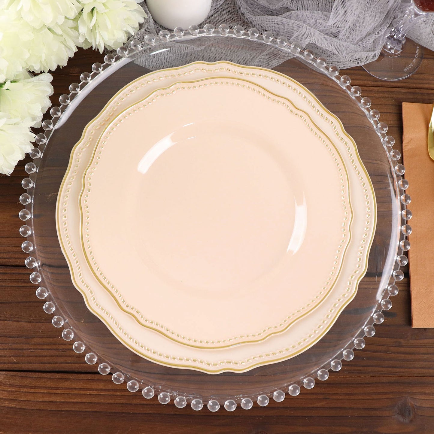 Elegant layered plates on a clear charger with beaded edges, perfect for table settings.