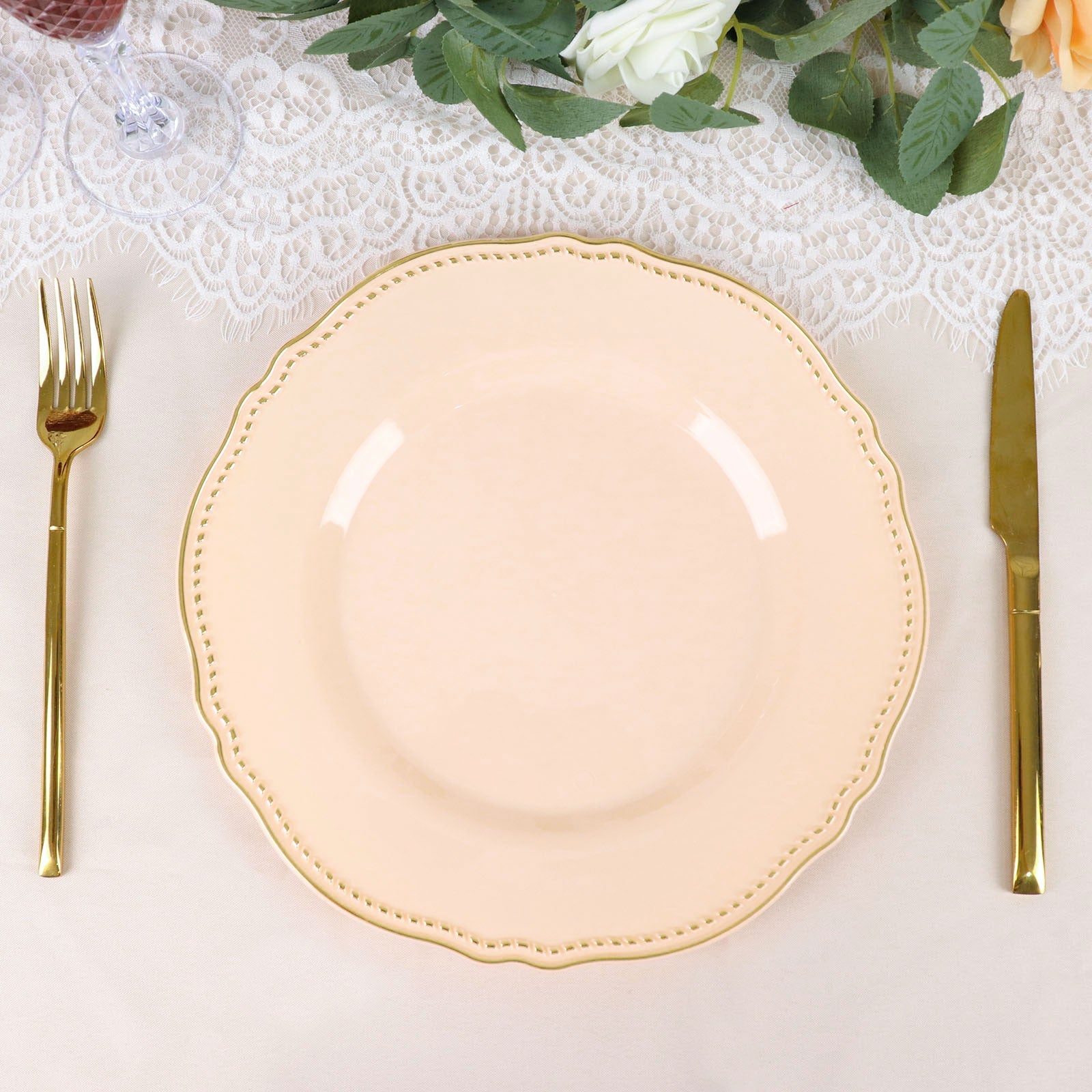 Elegant peach plate with gold cutlery on a lace table setting. Perfect for dining decor.
