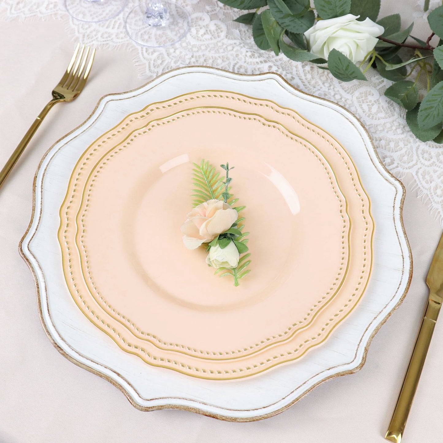Elegant pink dinner plate with floral accents on a decorated table setting.