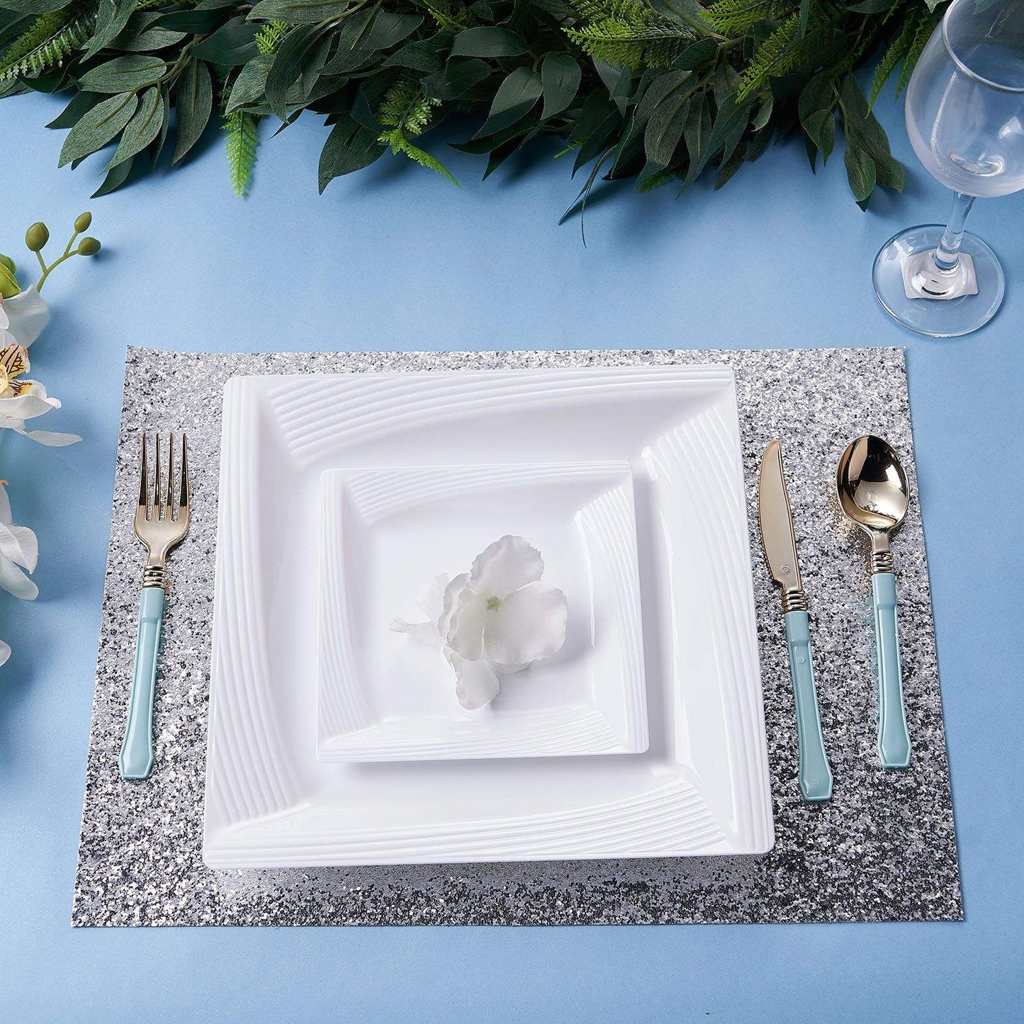White geometric ridge trim plastic salad plates on a table setting.