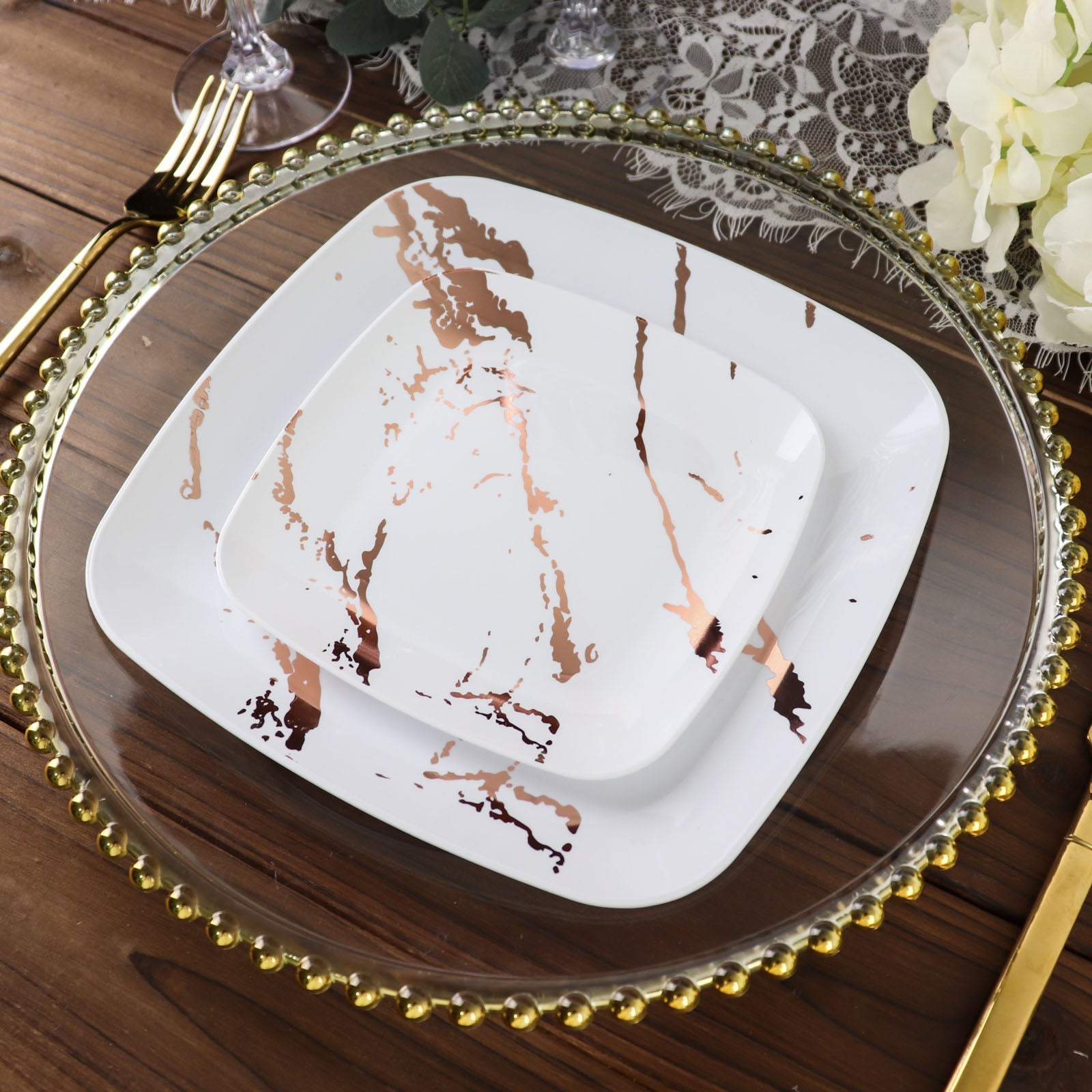 White rose gold marble square plastic dessert plates on a table setting.