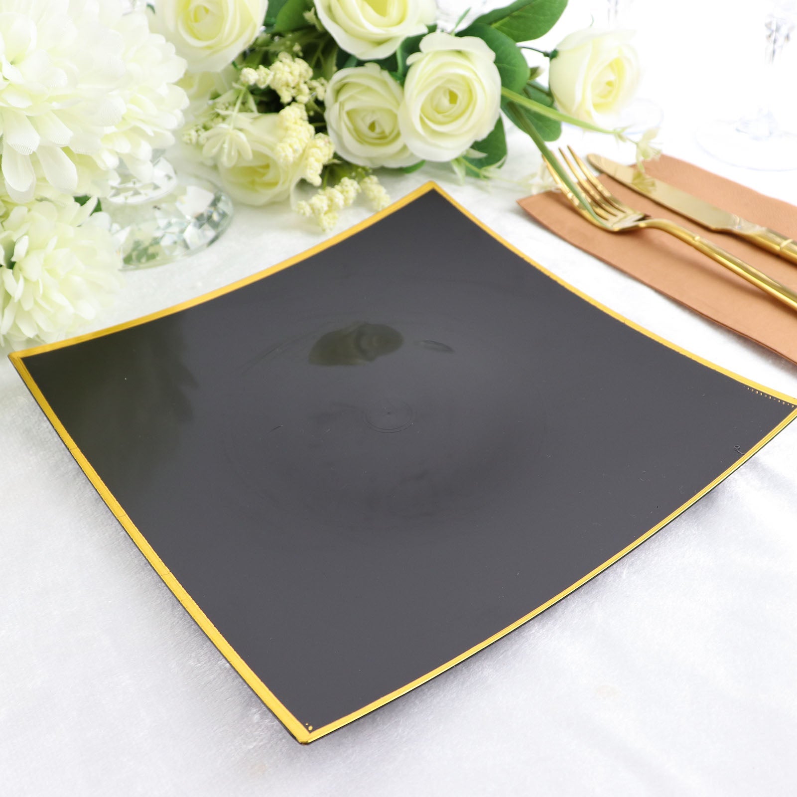 10" black and gold square disposable dinner plate on a table setting.