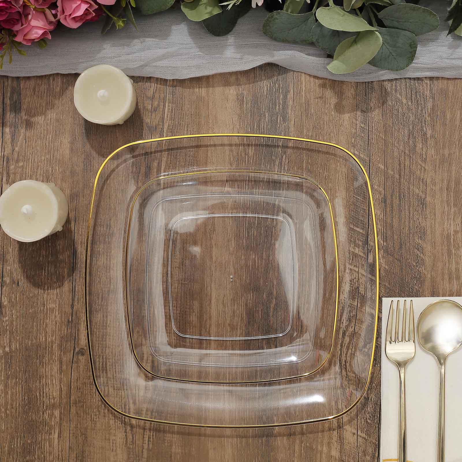 Clear with gold rim square plastic dessert party plates on a wooden table.