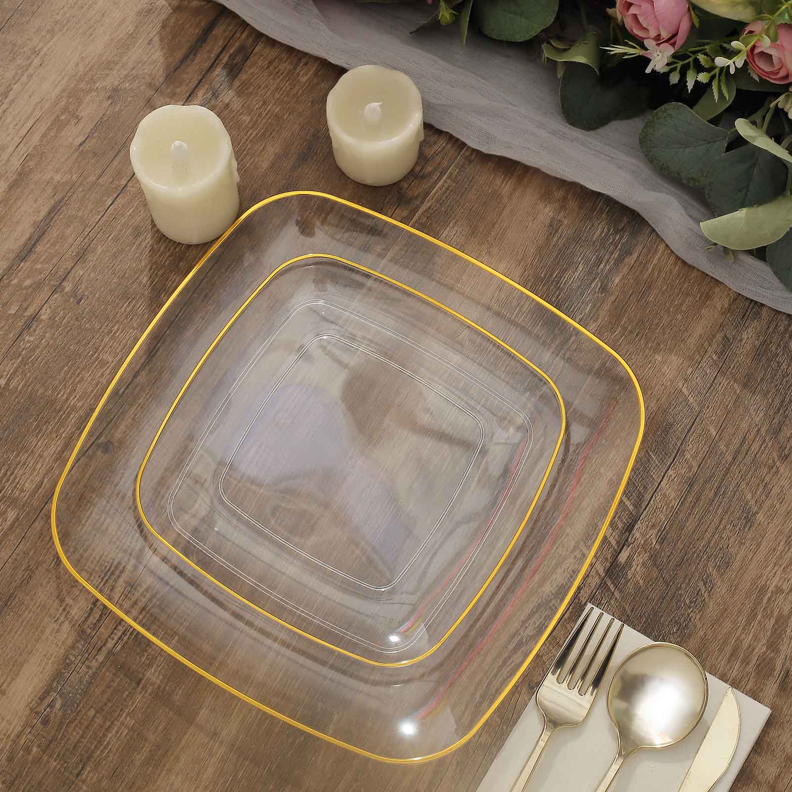 Clear with gold rim square disposable dessert plates on a wooden table.