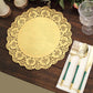 Gold lace paper doily on a wooden table with utensils and glassware.