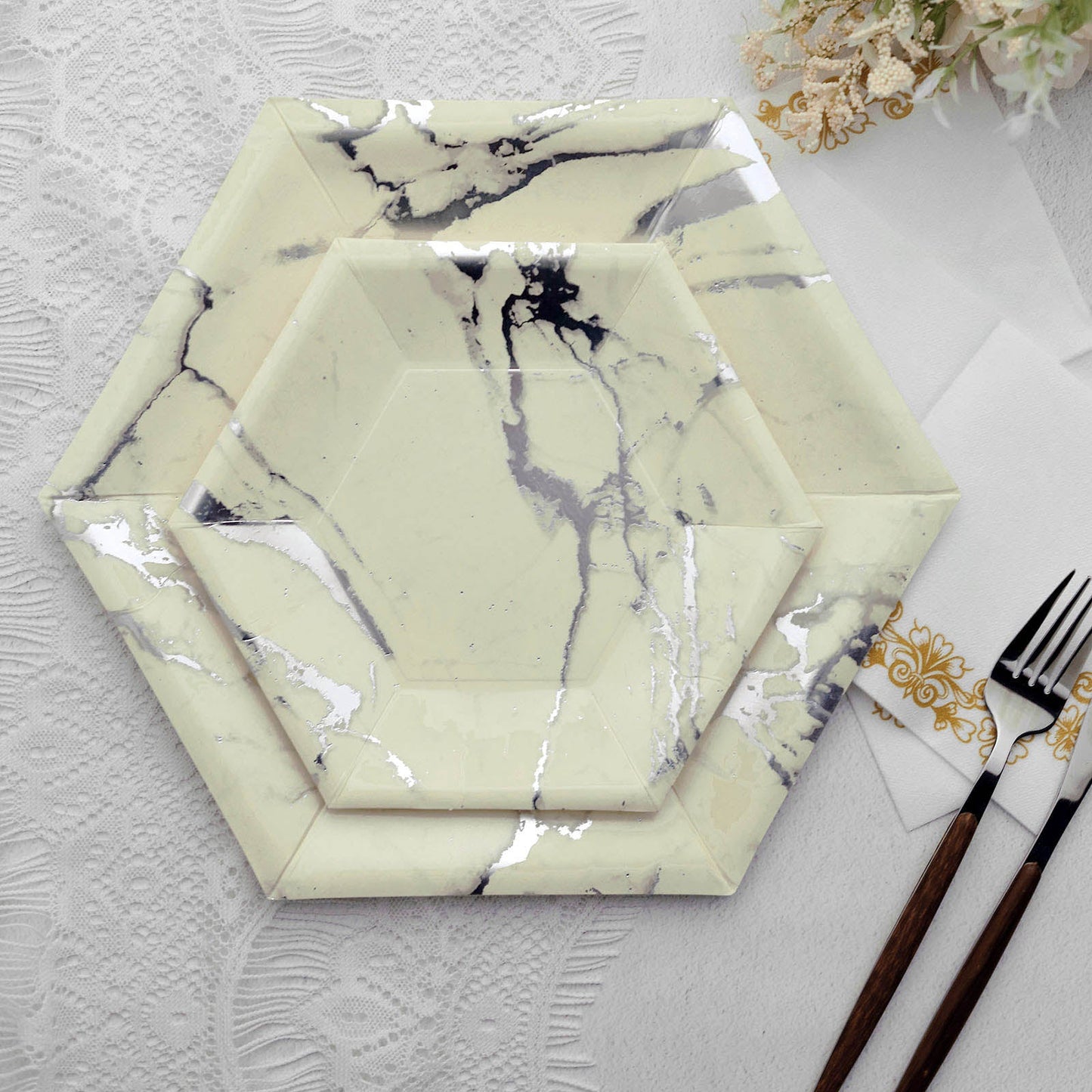 Ivory marble hexagon plates with silver foil design on a white background.