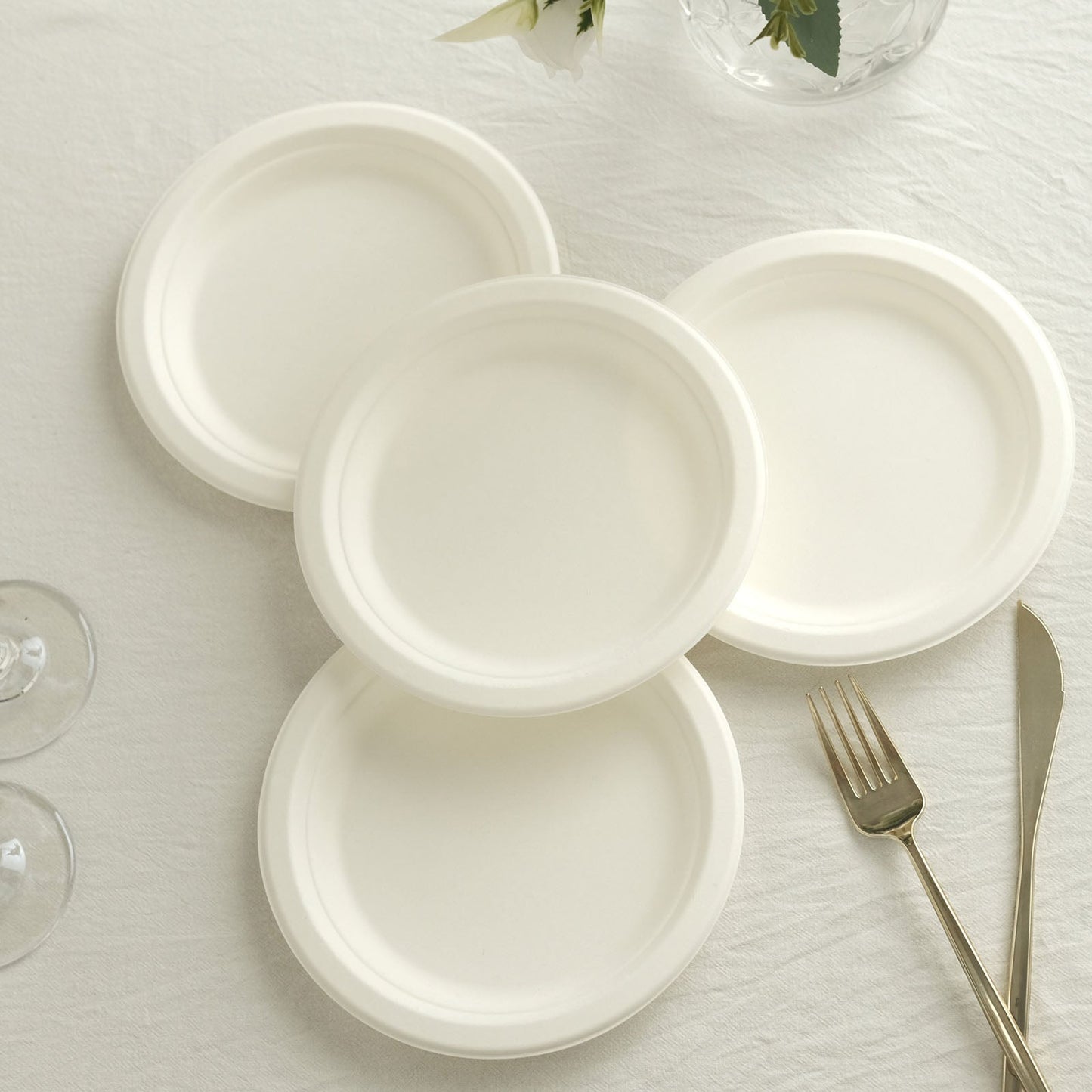 White biodegradable bagasse dessert plates stacked on a table.