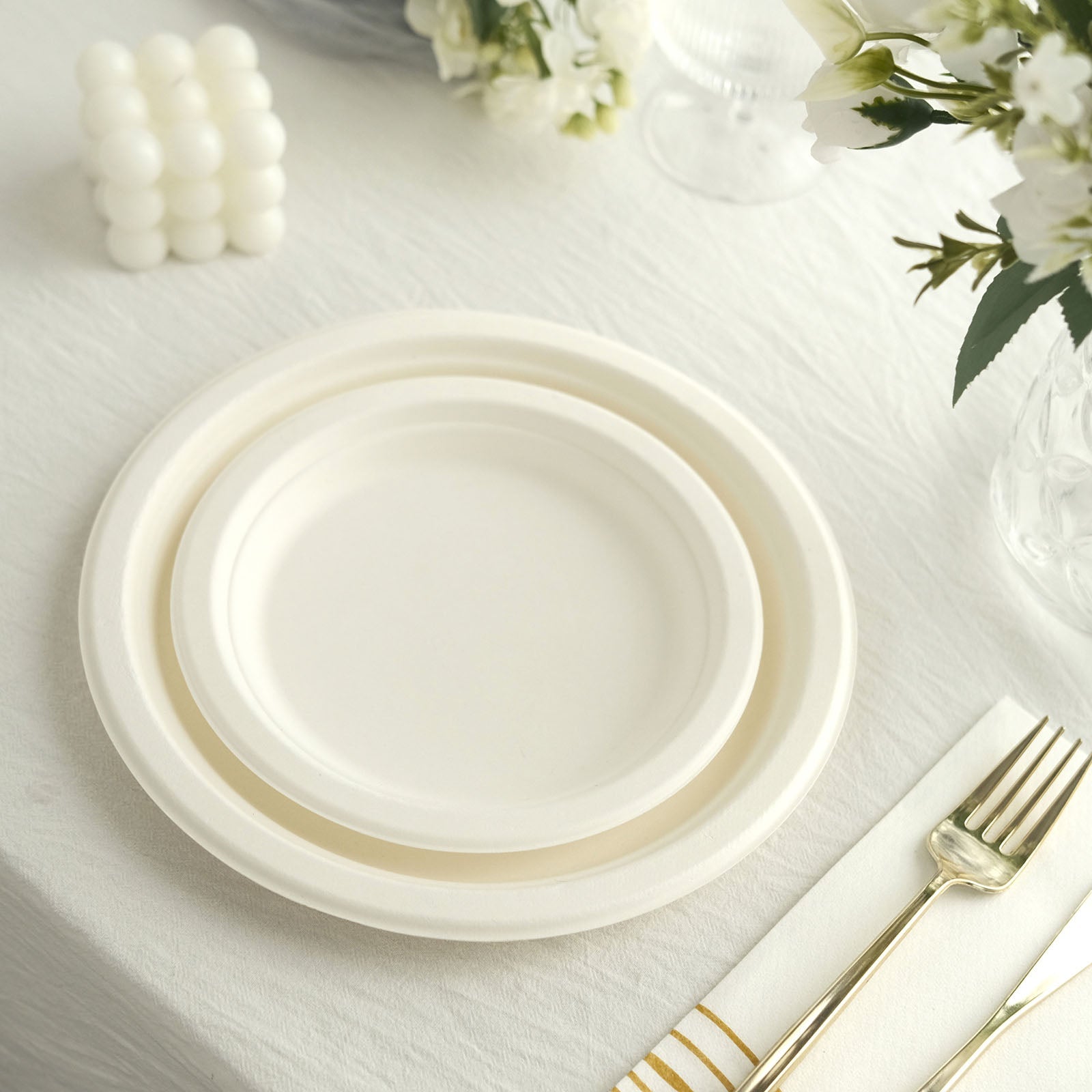 White biodegradable bagasse dinner plates on a table setting.