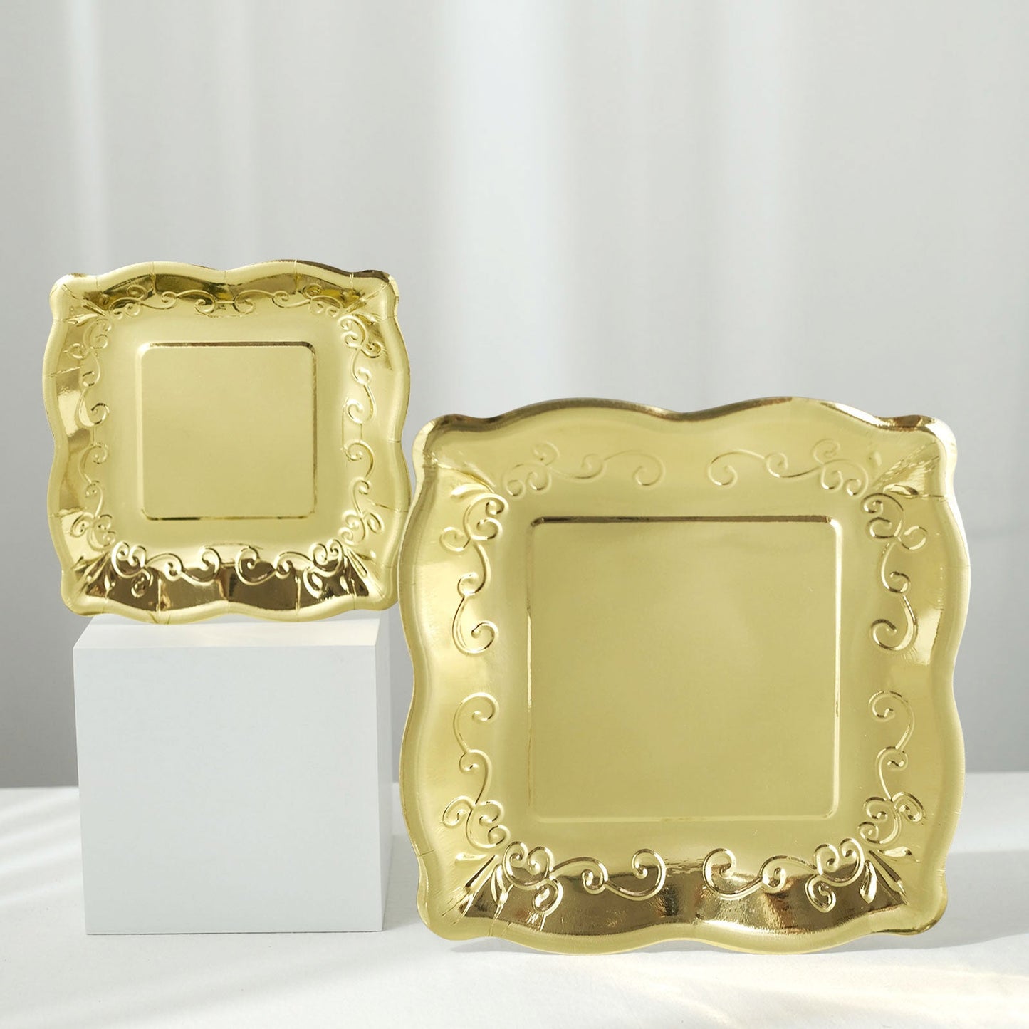 Gold vintage square dinner plates with embossed scroll design.