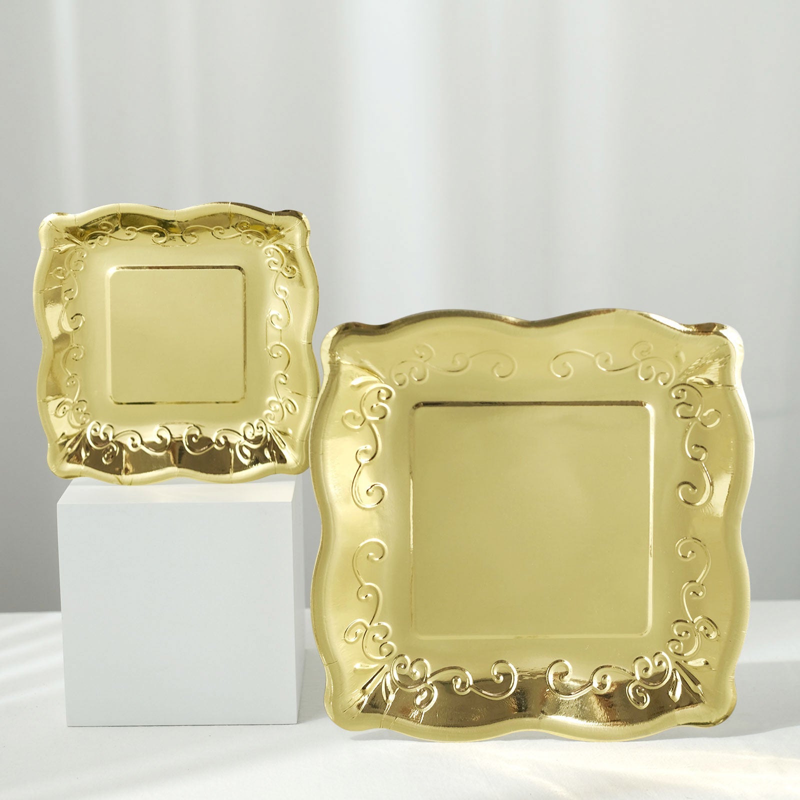 Gold vintage square dinner plates with embossed scroll design.