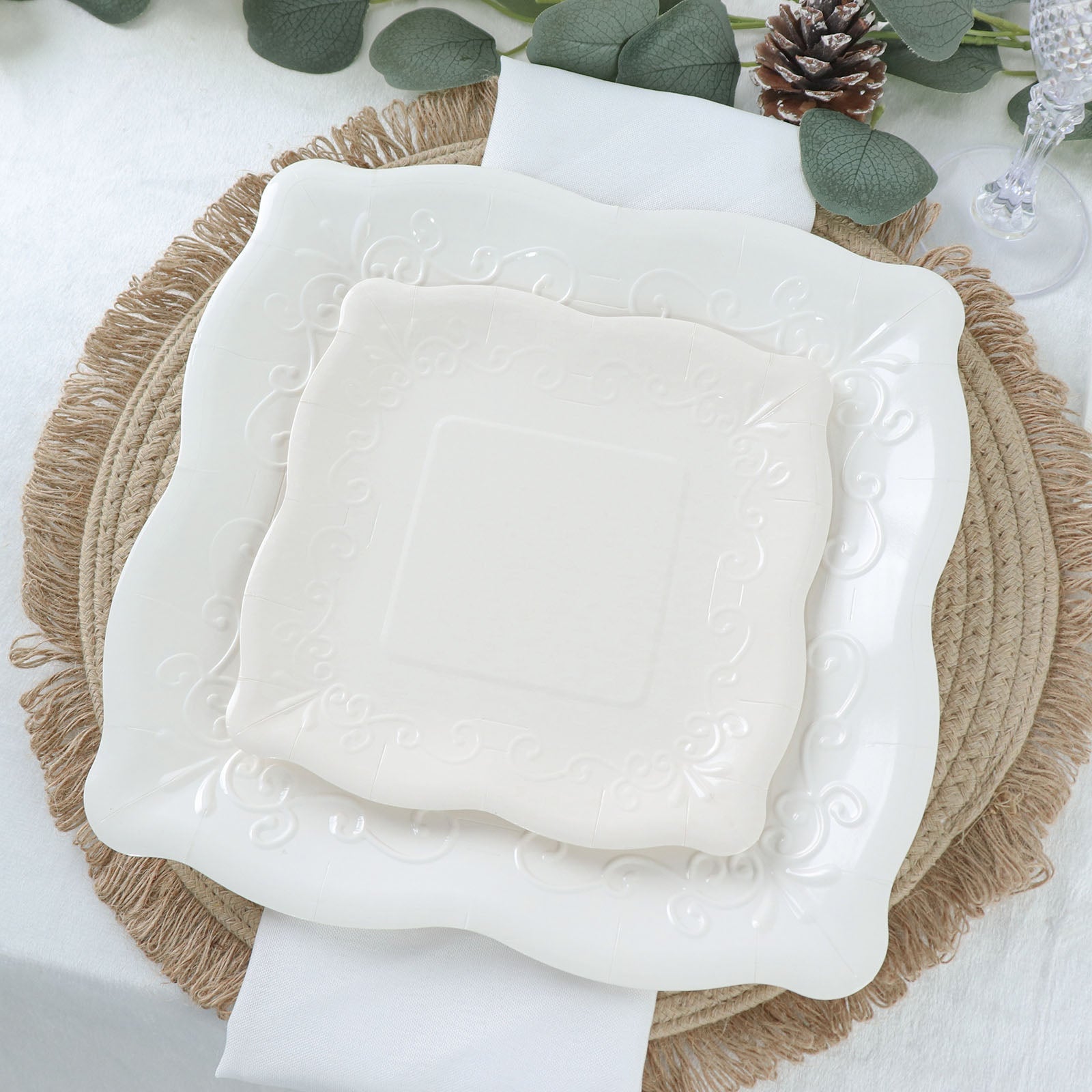 White vintage dinner serving paper plates with embossed scroll design.