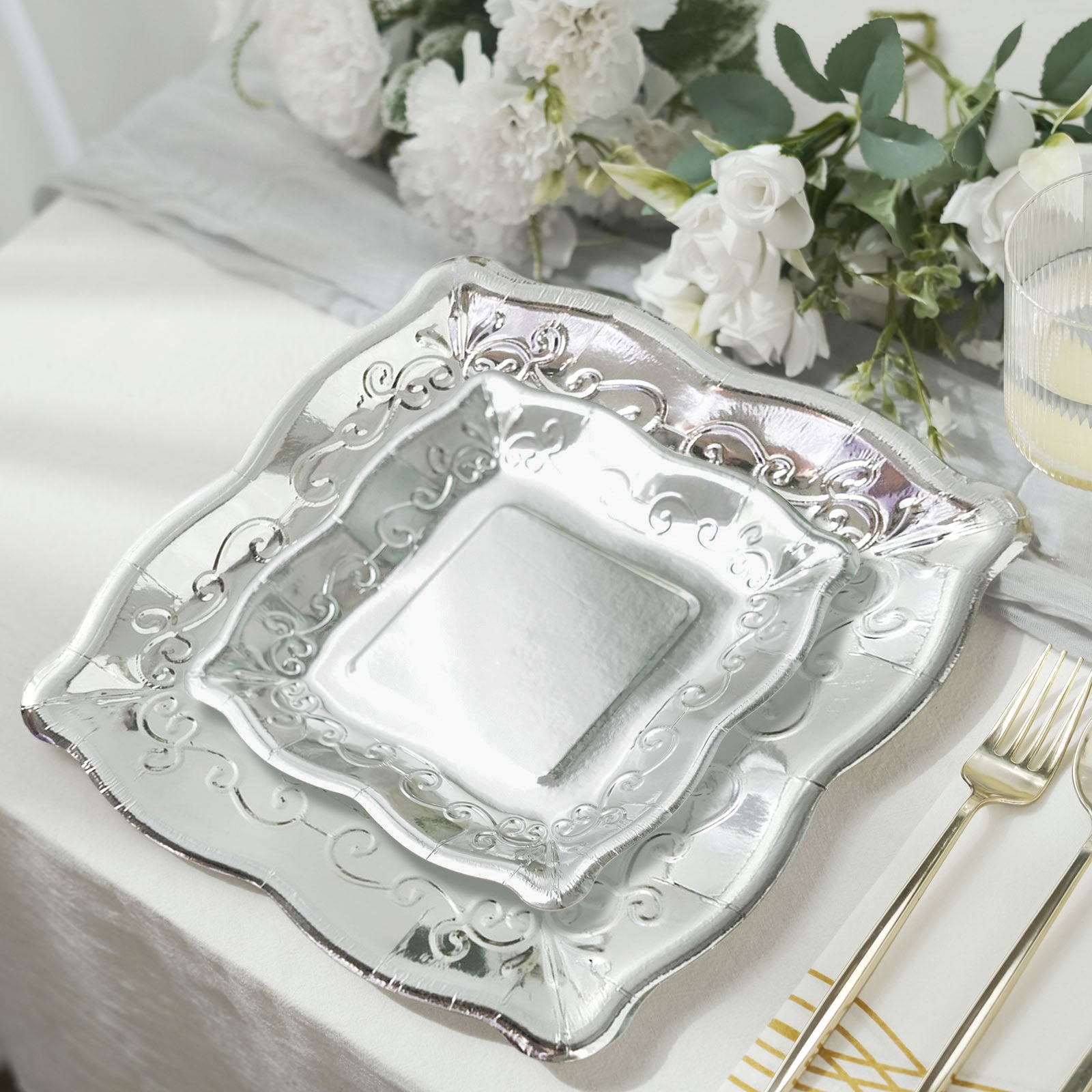Silver vintage square appetizer plates with embossed scroll design.
