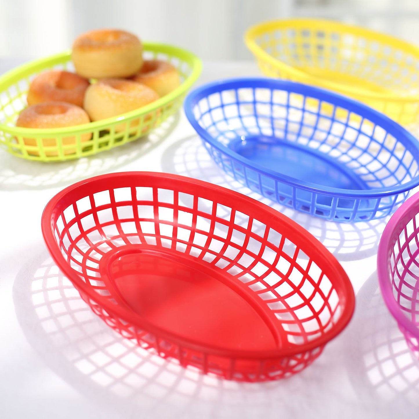 Colorful red oval plastic food basket with wax paper liners.