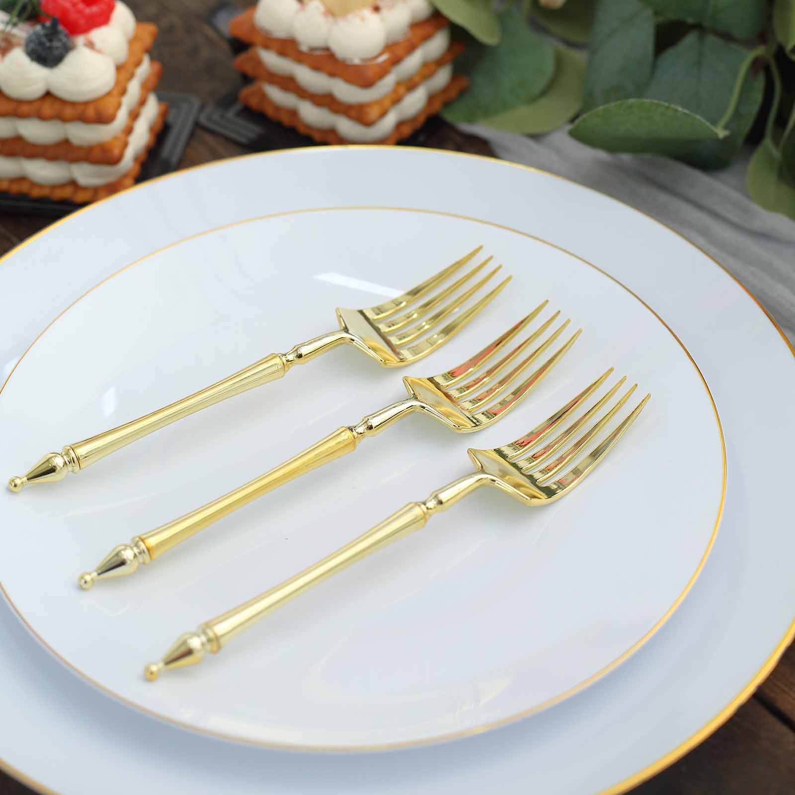 Gold plastic dessert forks with Roman column handle on a white plate.