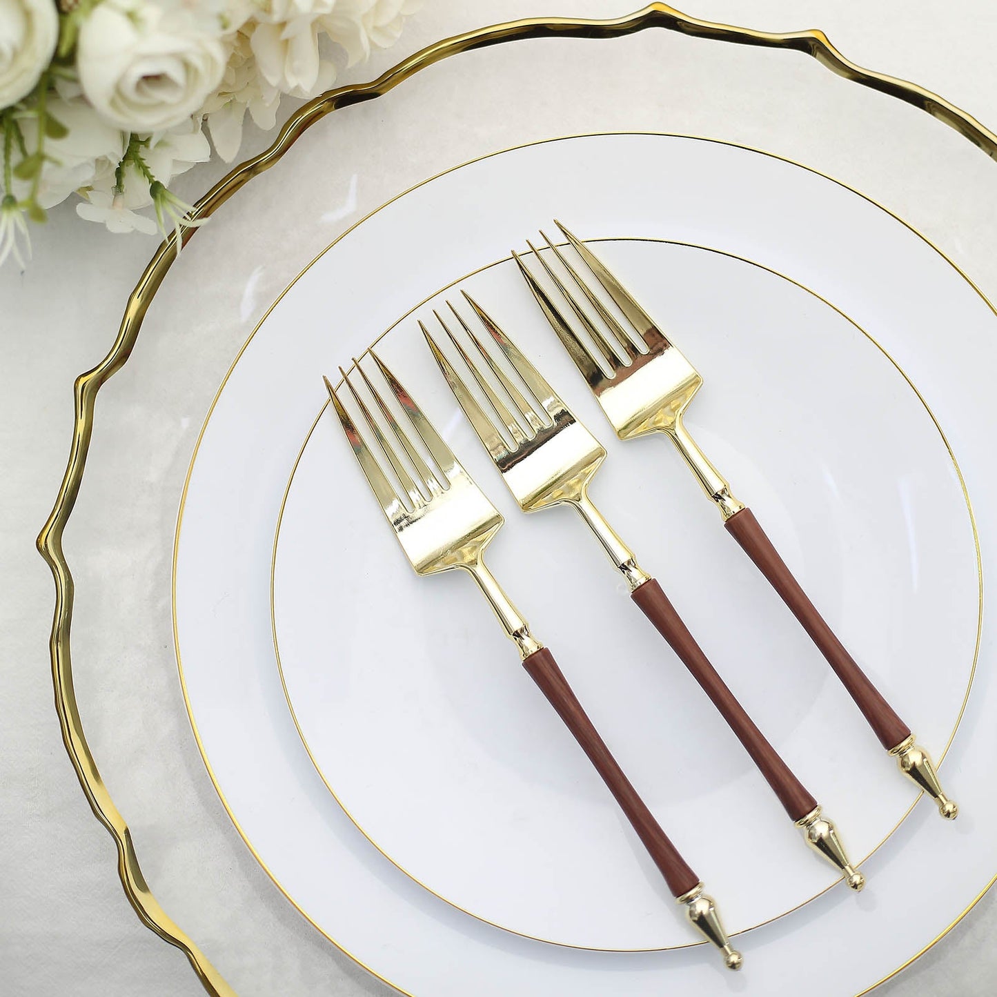 Gold and brown plastic forks with Roman column handle on elegant plates.