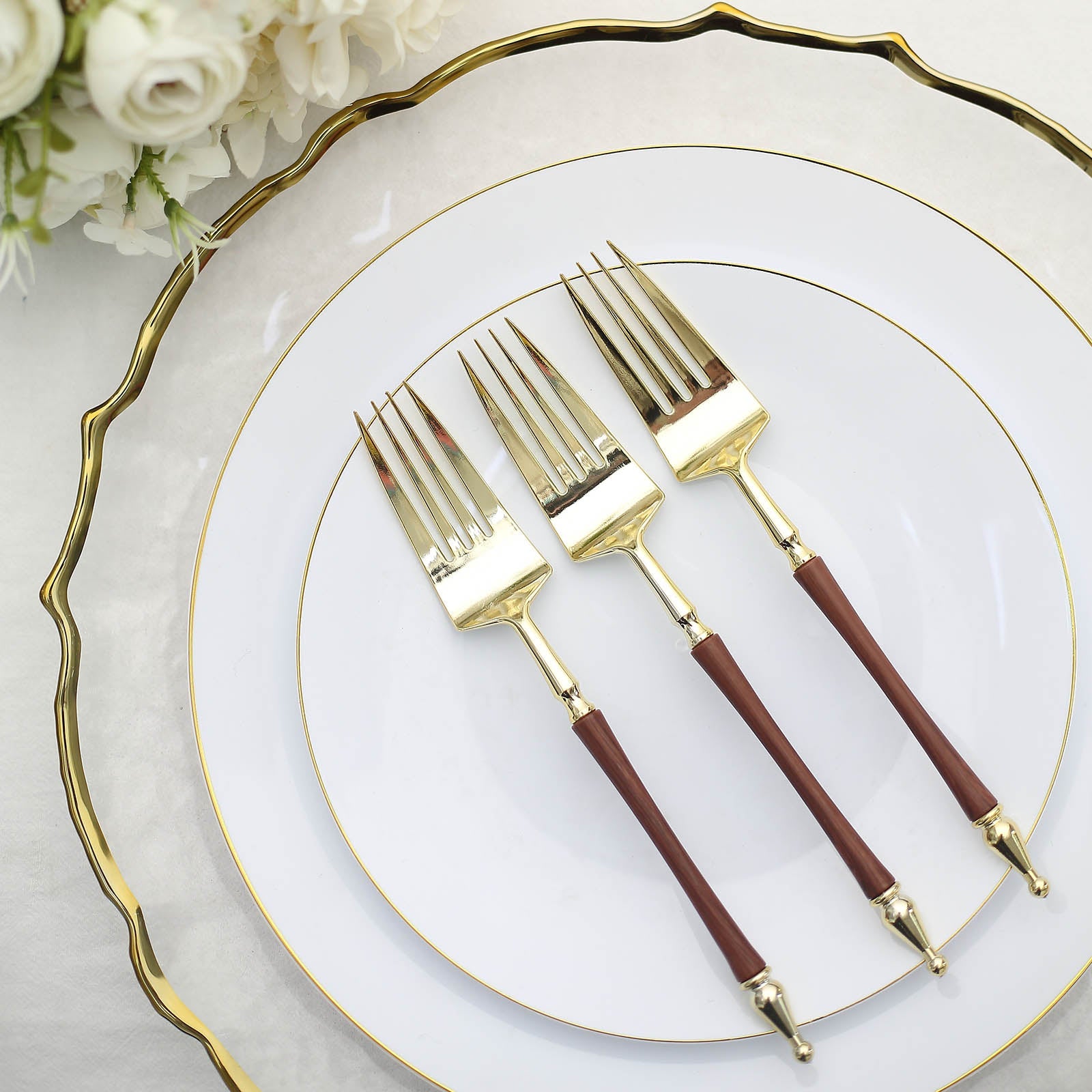 Gold and brown plastic forks with Roman column handle on elegant plates.