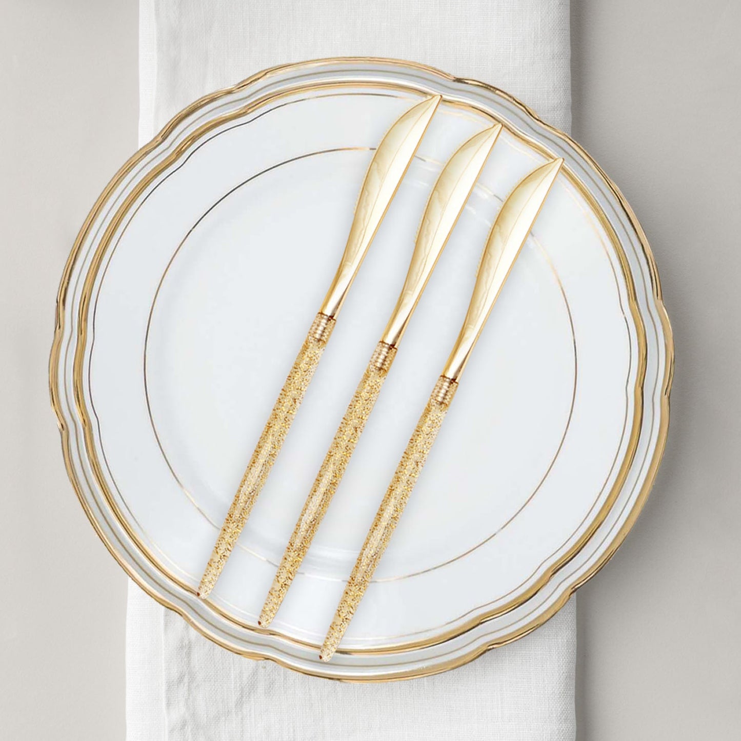 Gold glittered disposable knives on an elegant plate.
