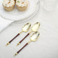 Gold and brown disposable dessert spoons with Roman column handle.
