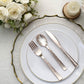 Rose gold hammered design plastic silverware set on elegant table setting.