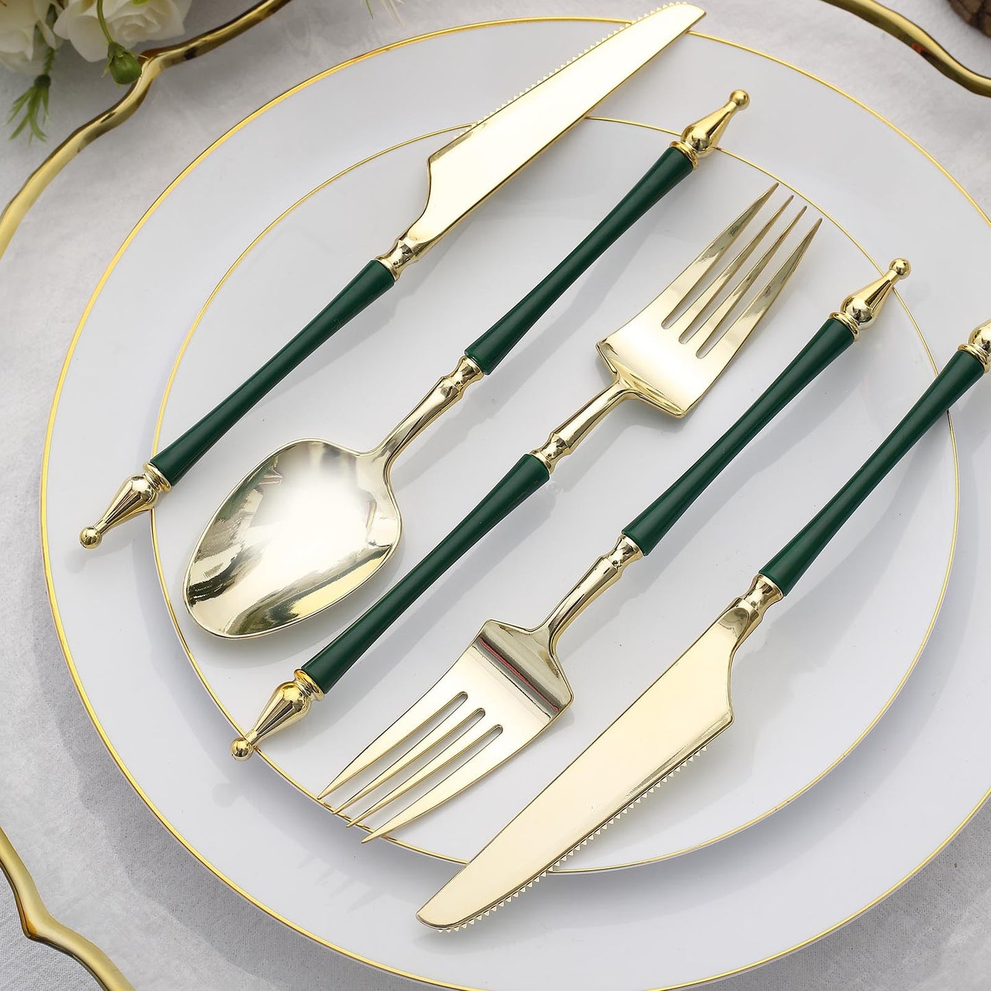 Gold and hunter emerald green disposable utensil set on a plate.