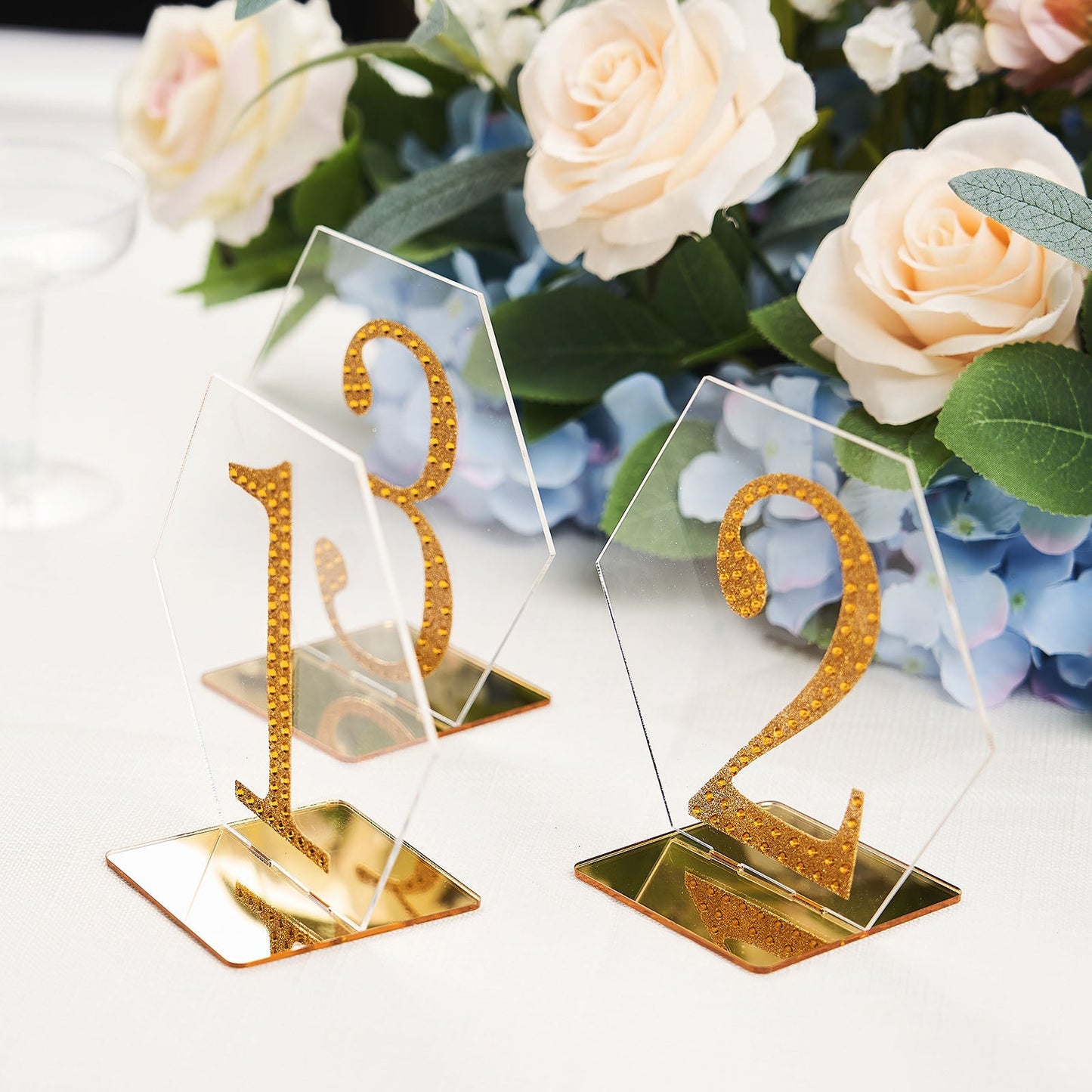 Clear and gold acrylic hexagon wedding table sign holders.