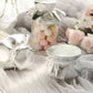 Metallic silver round jar covers with satin ties for party favors.