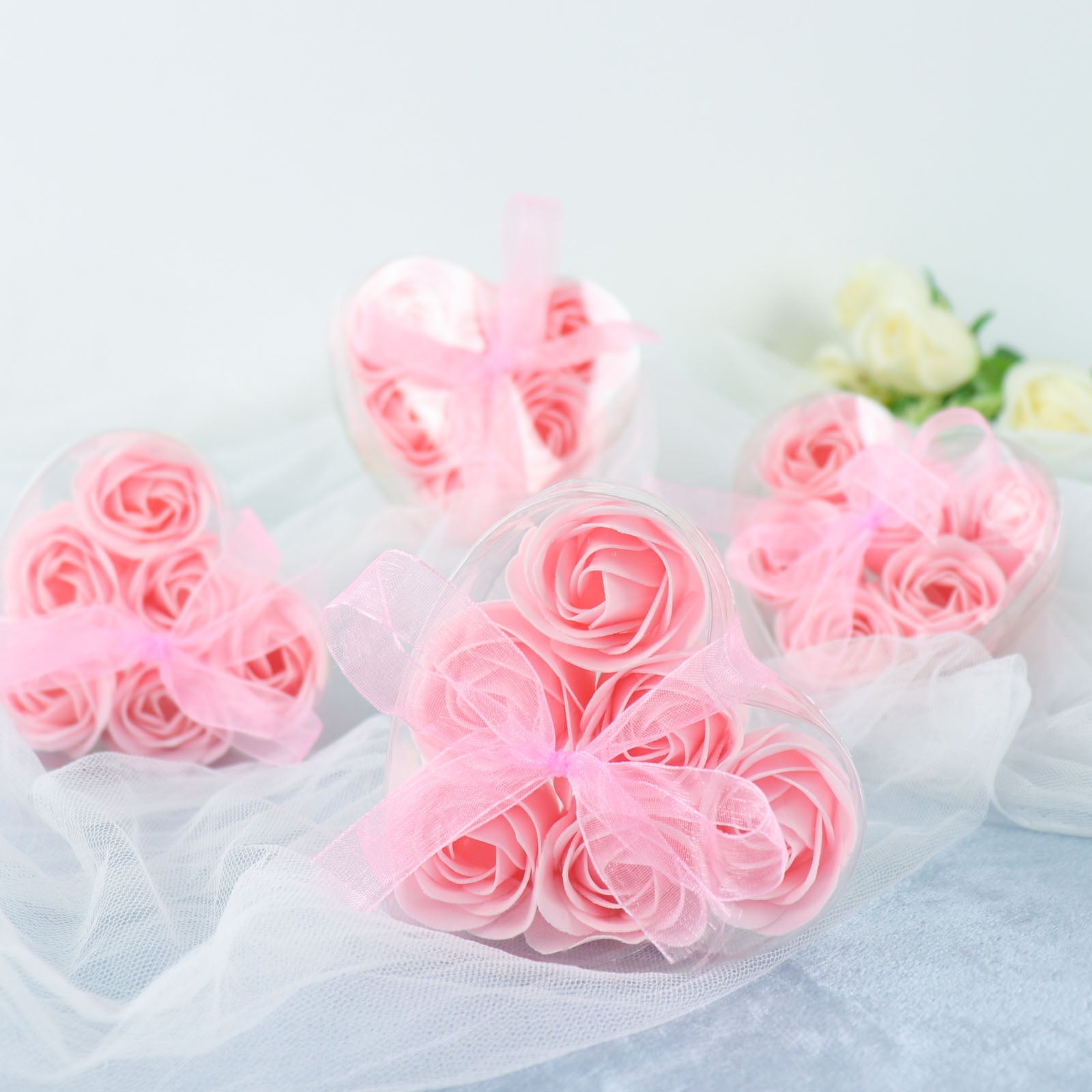 Blush pink rose soap heart party favors in gift boxes with ribbons.