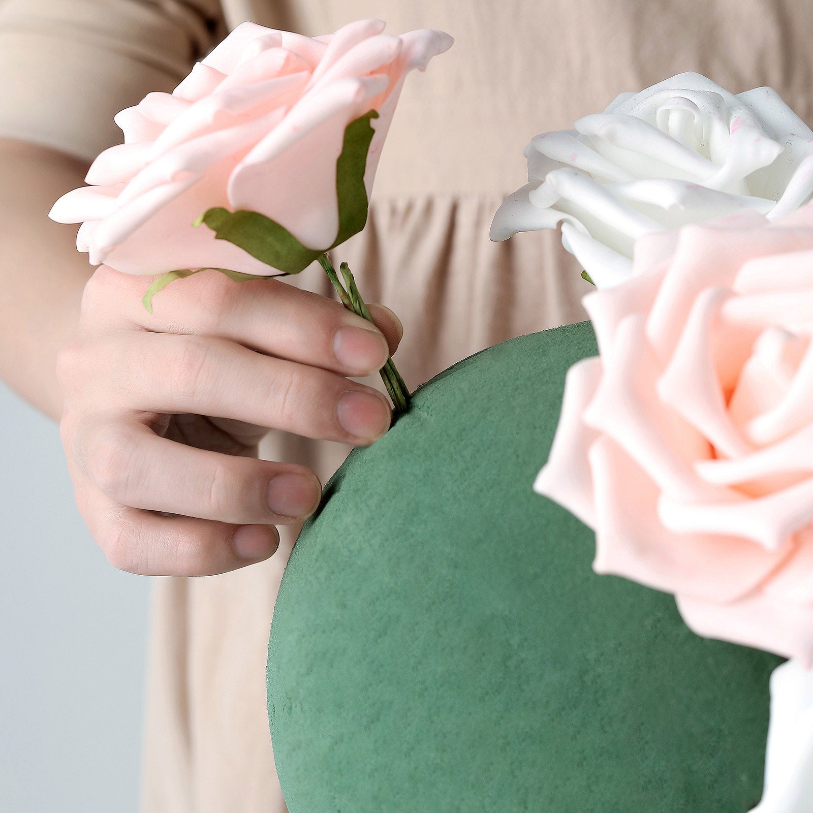 Green DIY floral foam ball with pink and white flowers.
