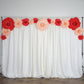 Large red artificial foam DIY craft roses on a white backdrop.