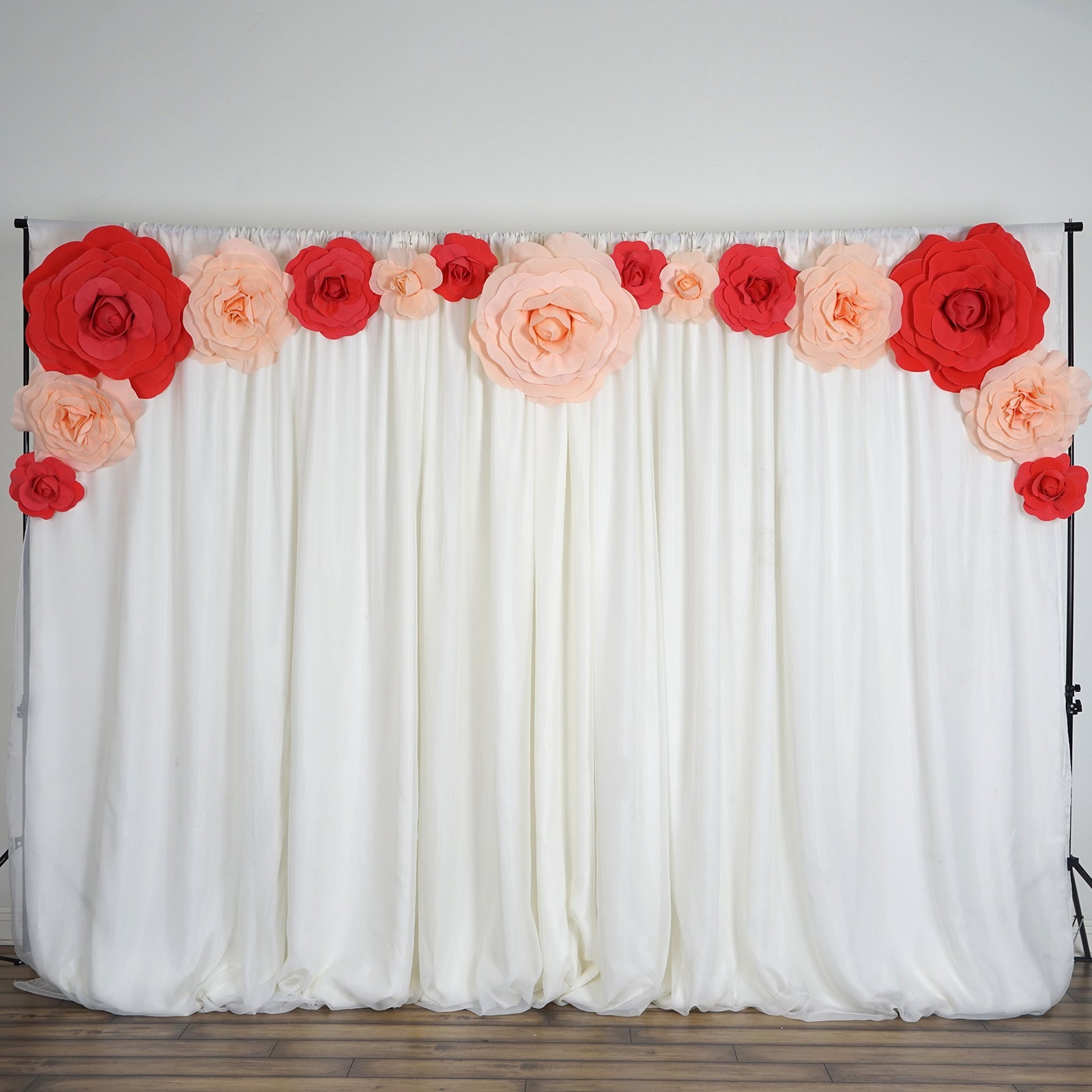 Large red artificial foam DIY craft roses on a white backdrop.