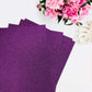 Purple self-adhesive glitter craft foam sheets arranged with flowers.