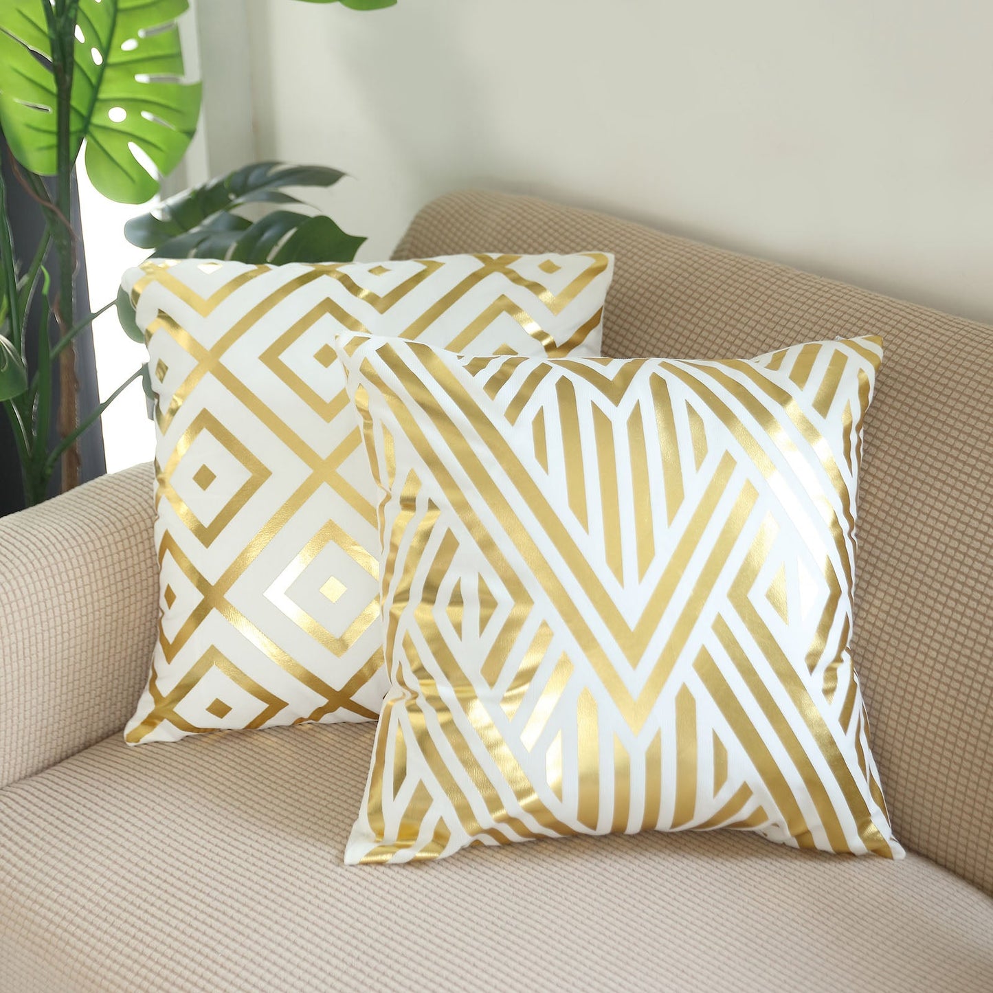 18" white and gold foil geometric print throw pillow covers on a sofa.