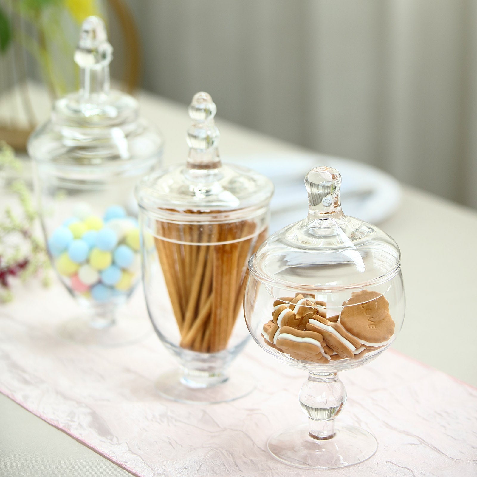 Clear glass apothecary jars with snap-on lids for decorative storage.
