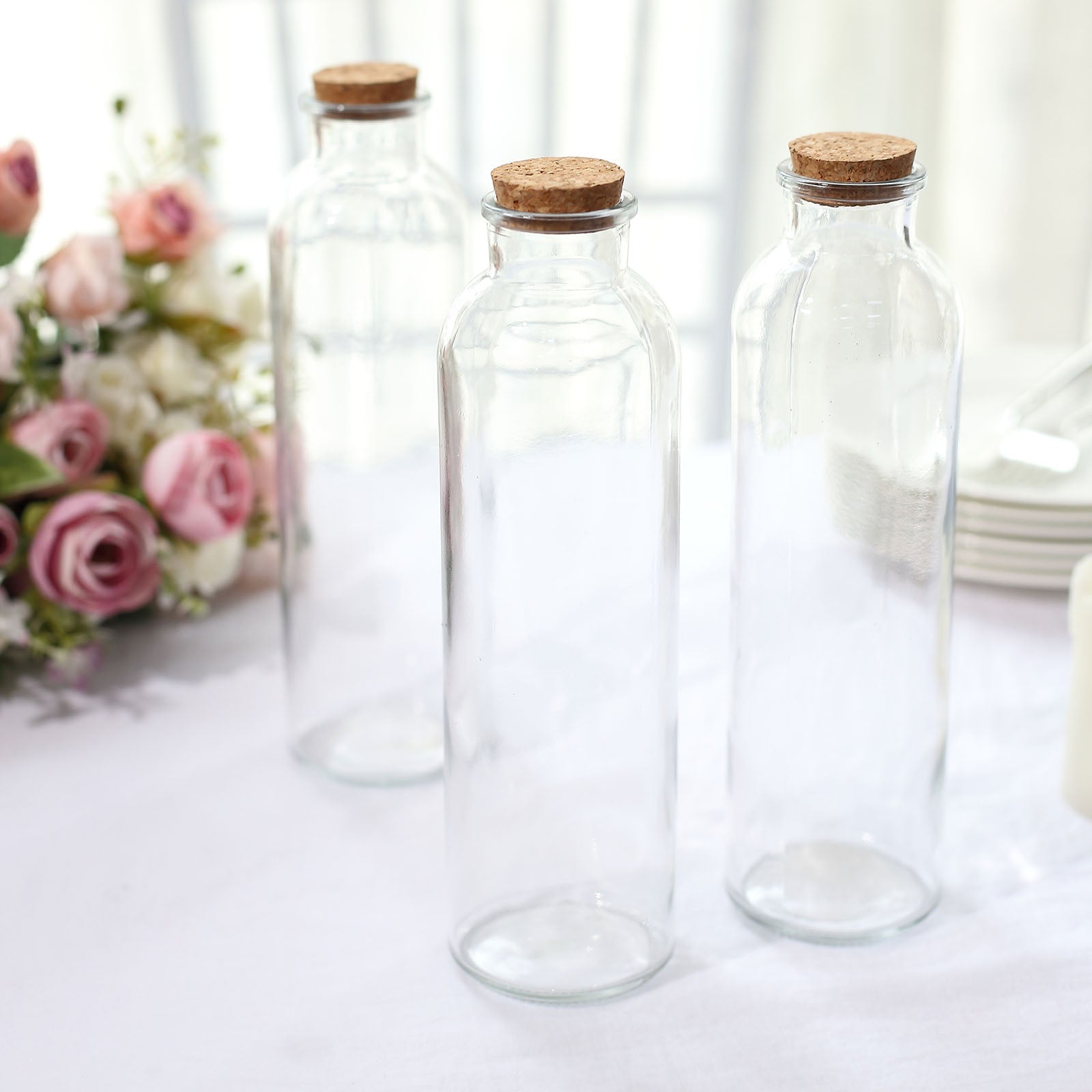 Clear glass storage jars with cork stoppers.