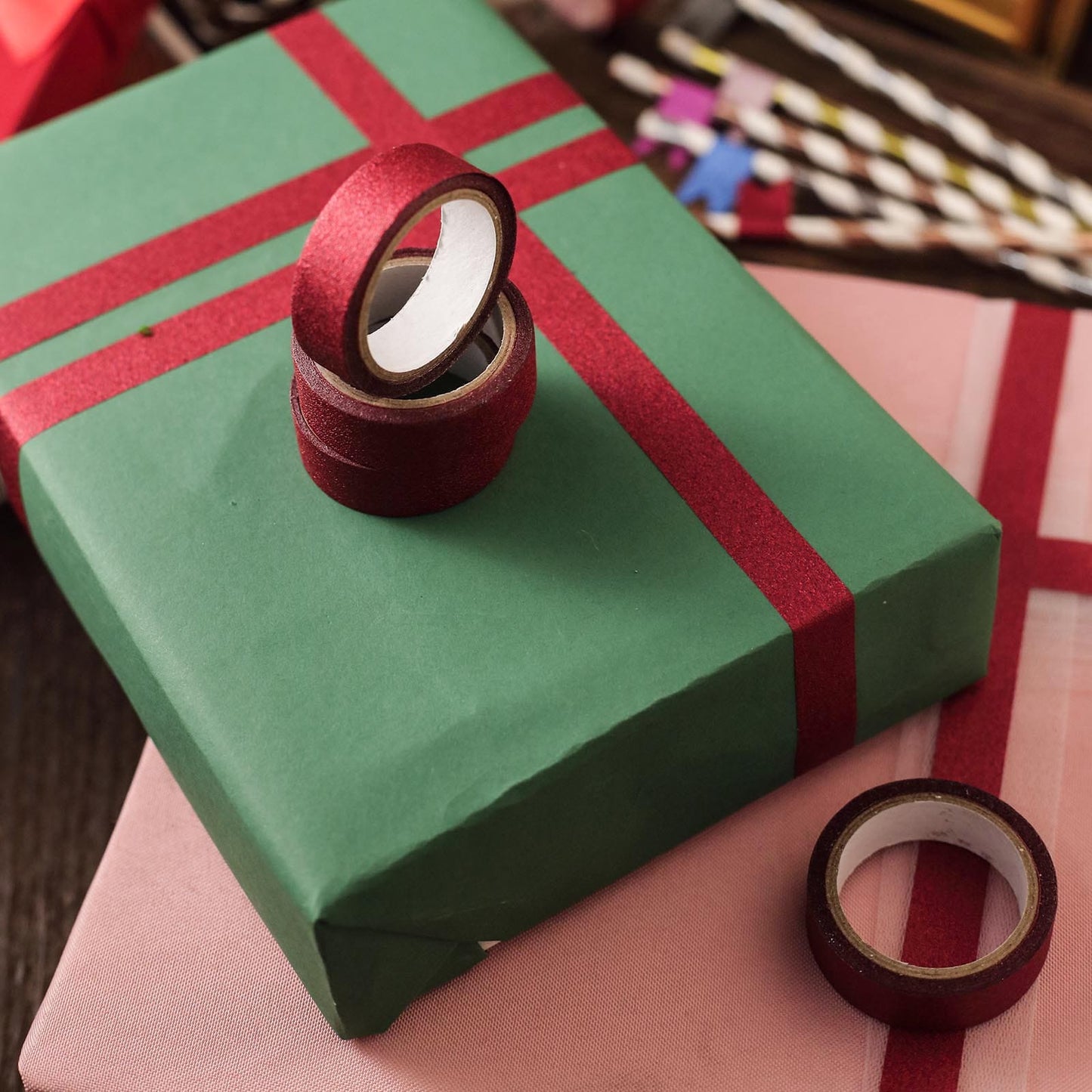 Burgundy washi tape rolls on wrapped gifts for DIY craft projects.