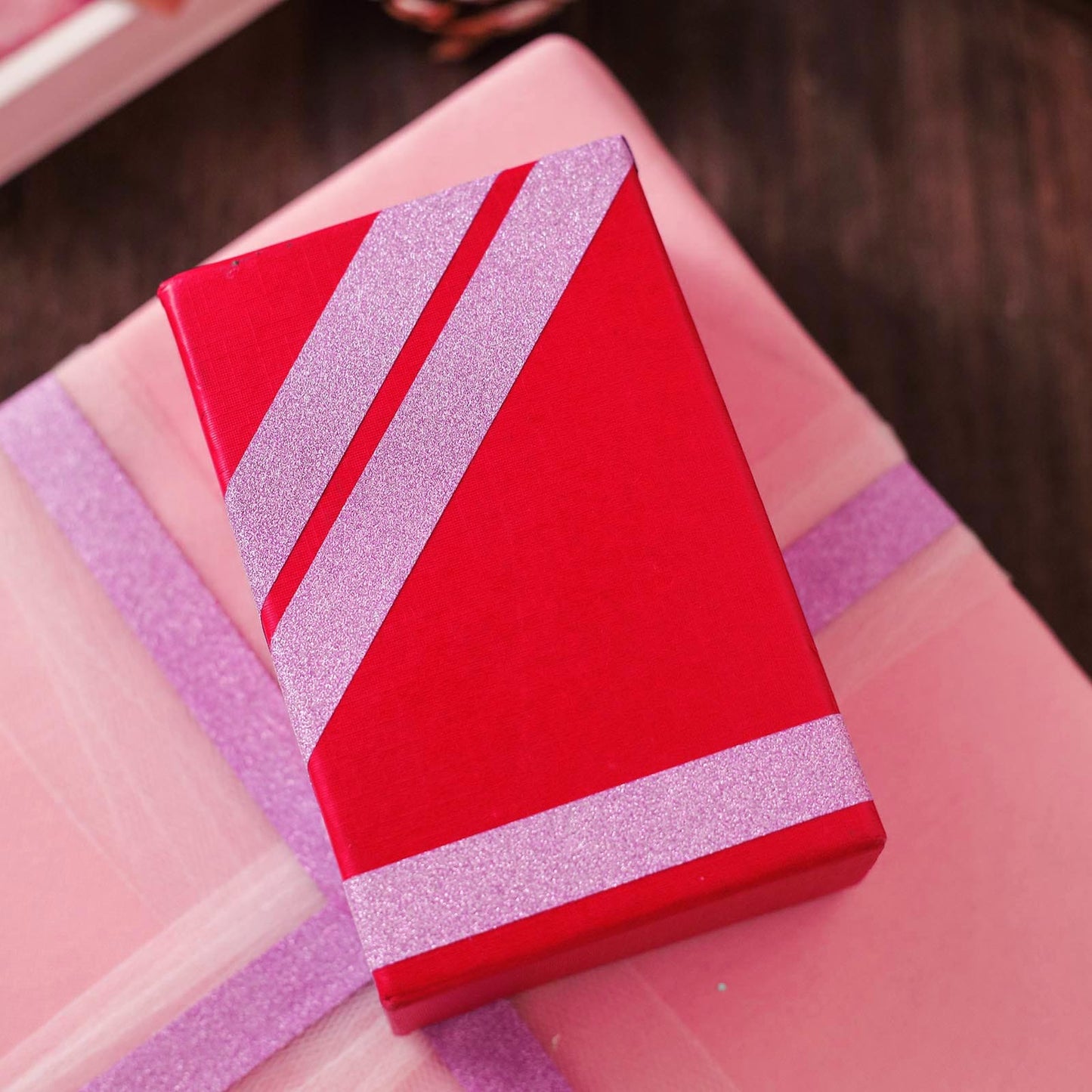 Purple glitter washi tape on a red gift box.