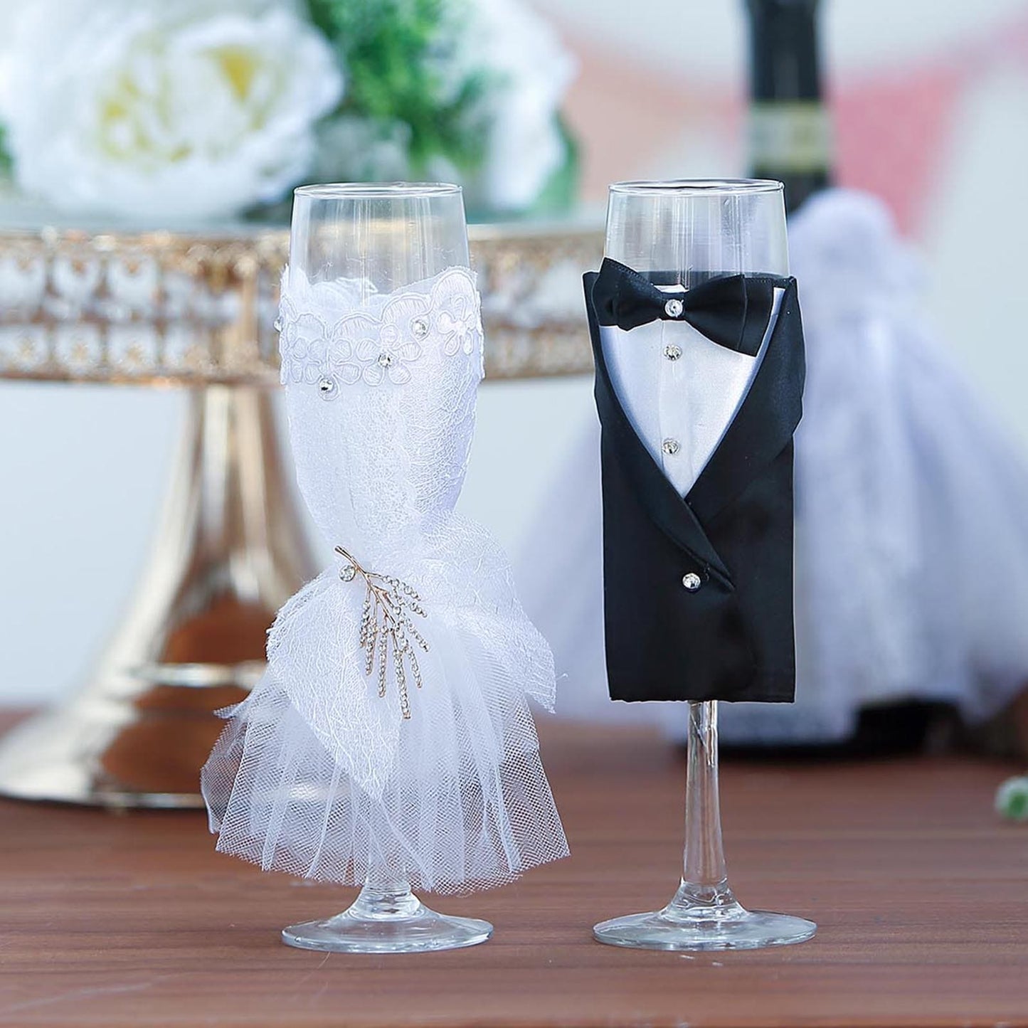 Set of 2 black and white wedding toast flutes with bride and groom designs.