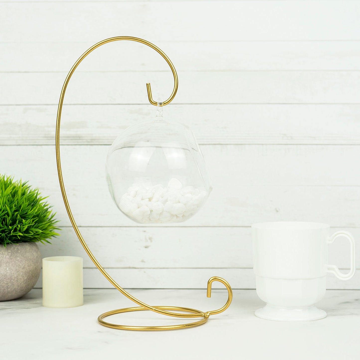 Gold metal air plant terrarium stand with hanging ornament display holder.