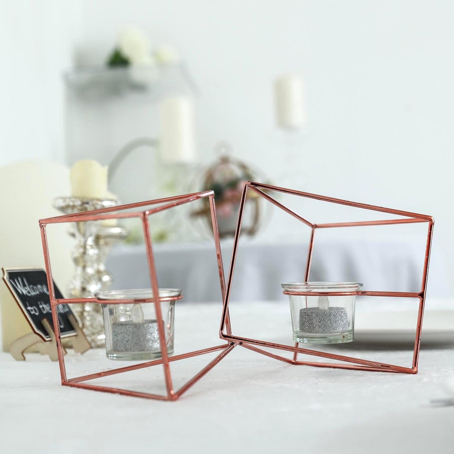 Rose gold geometric candle holder set with votive glass holders.