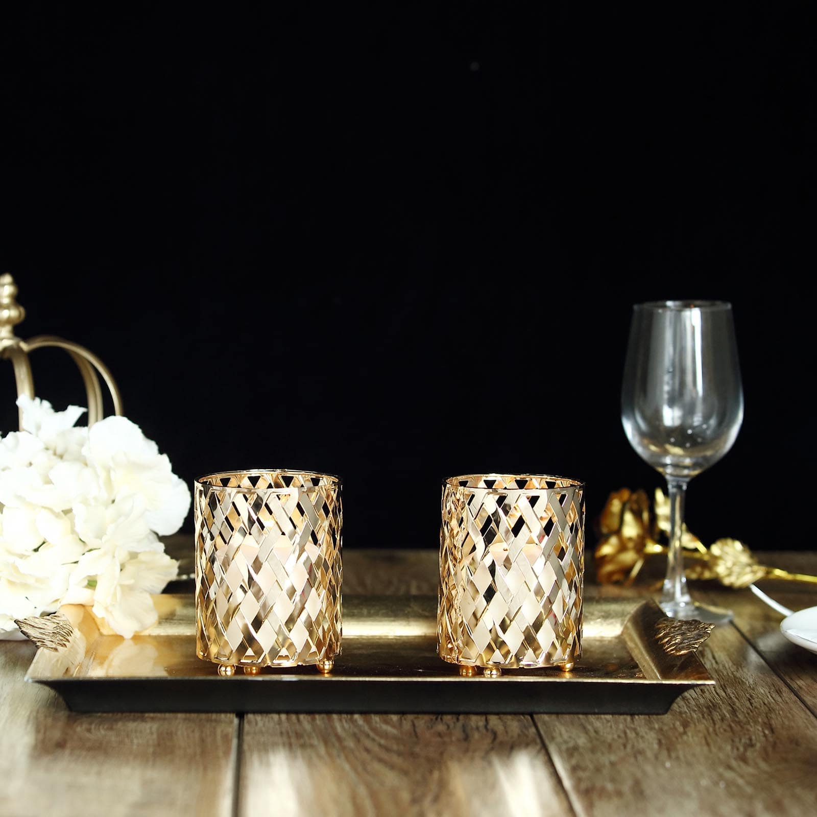 Gold metal diamond cut votive candle holders on a tray.