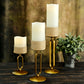 Gold metal oval frame pillar candle holders with white candles, assorted sizes.