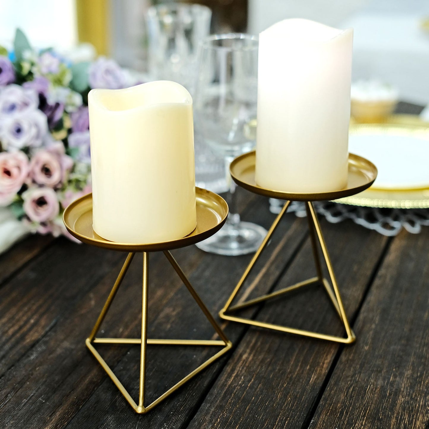 Gold metal triangle base candle holders with pillar candles.
